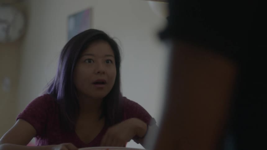 A woman uses sign language to communicate with someone giving her a plate of food