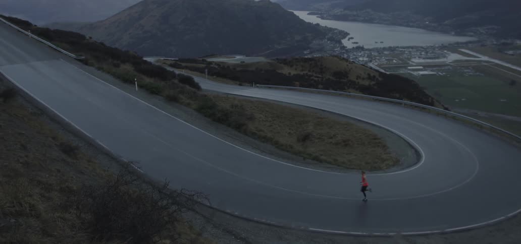 A person is running fast around a winding road