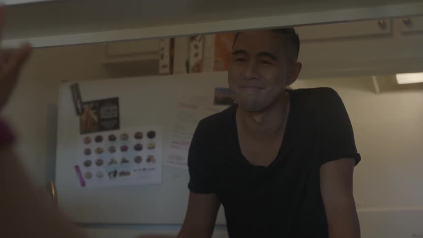 Man hands food and smiles at a customer