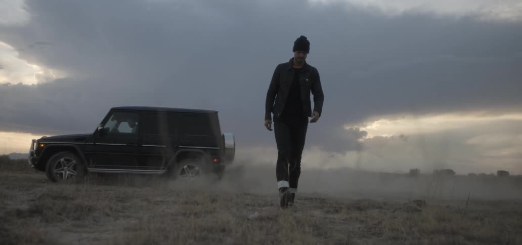 A truck drives off on the grass as a man walks off