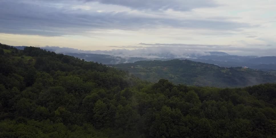 View of tree covered hills on a cloudy day