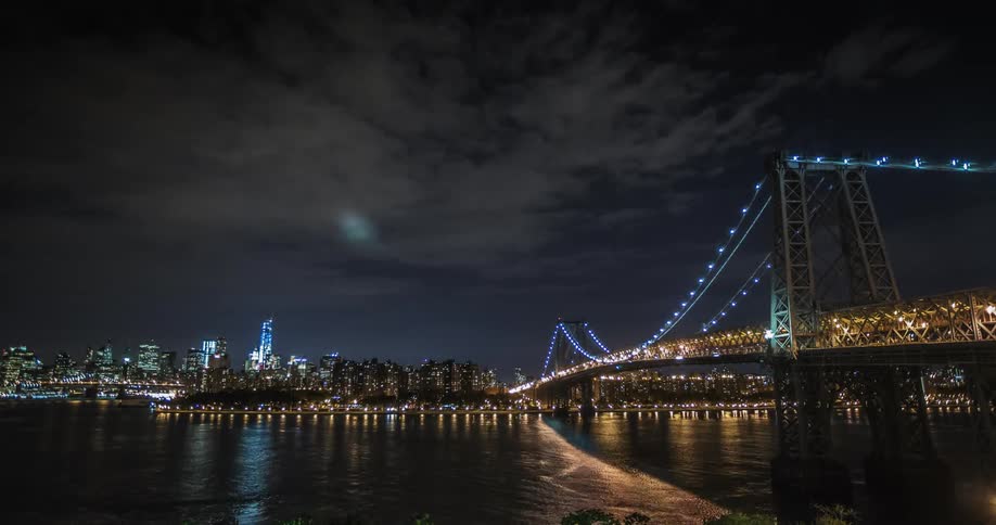 A river flows in front of a cityscape at night