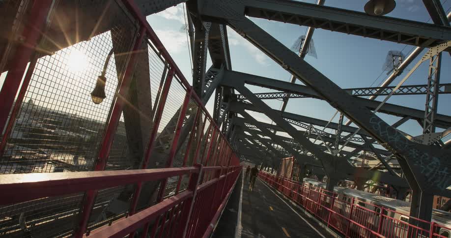 Bicyclists commute across a bridge during the day