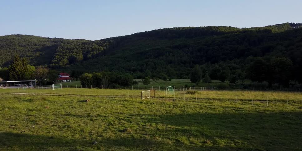Soccer nets sit in an open field in a rural area