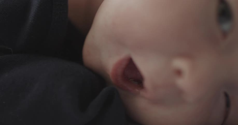 A baby is laying with it's mouth open