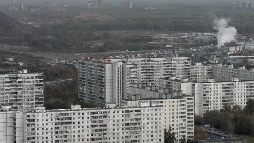 Rows of buildings have a busy highway behind them
