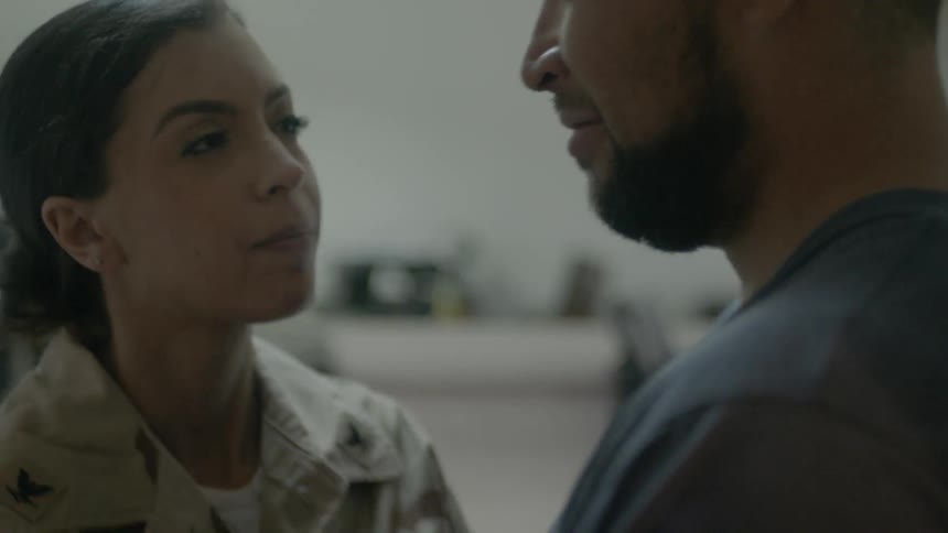 A bearded man hugs his wife before she leaves