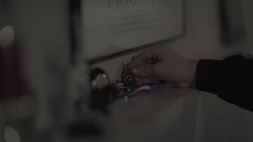 Person picks up a knickknack off a mantel