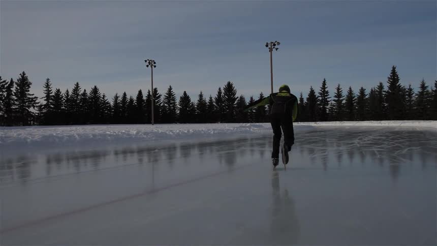 A man ice skates on a clear day