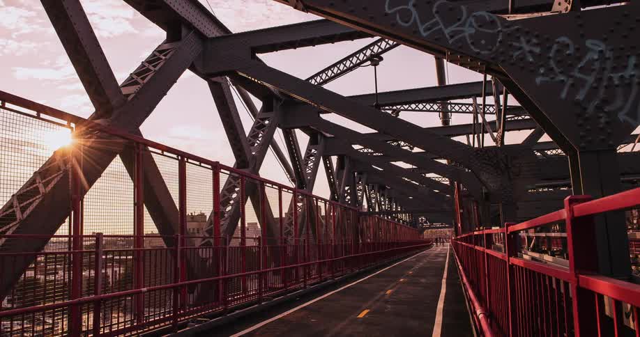 Pedestrians and bicyclists cross a city bridge