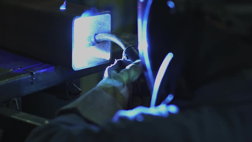 A welder is working on hollowed out metal beam