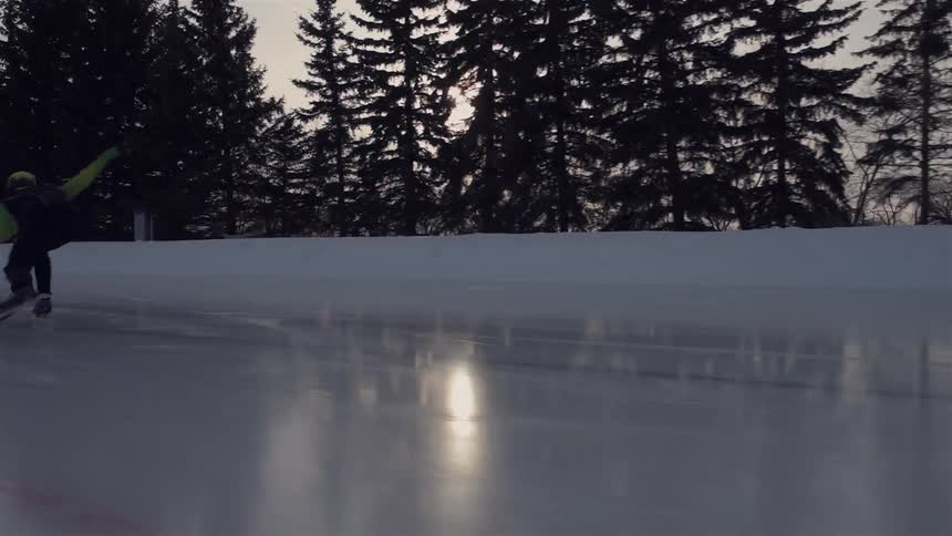 A speed skater skates by on an outdoor rink