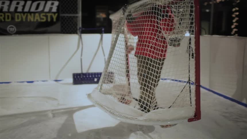 A man is moving a hockey net off the ice