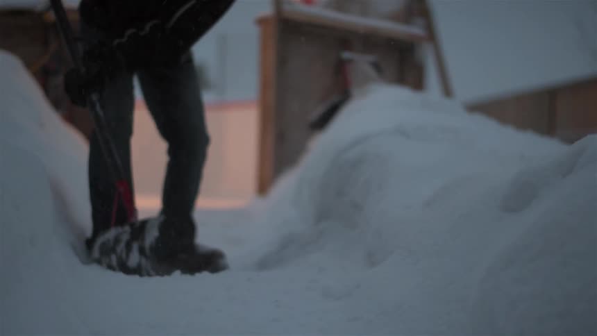 Person using a snow shovel to clear a pathway
