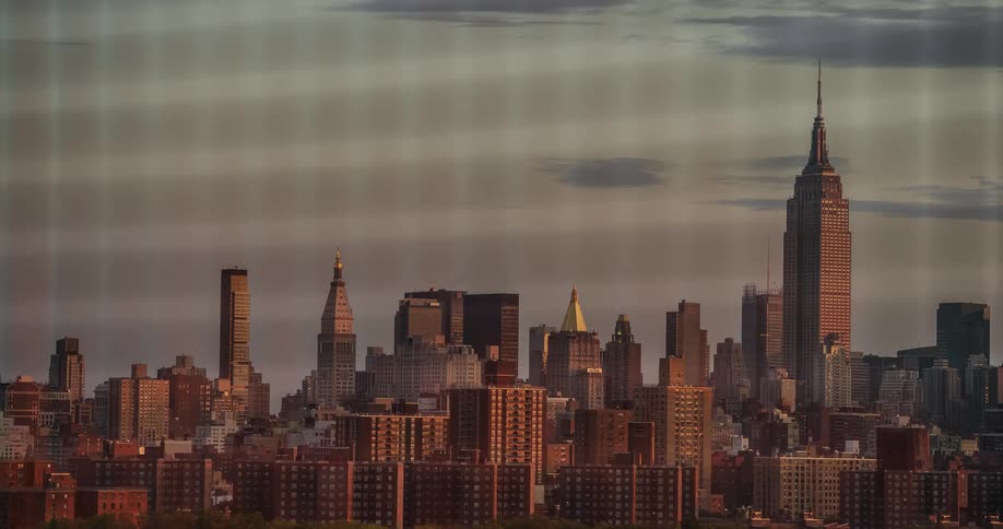 Clouds float over a cityscape at sunset