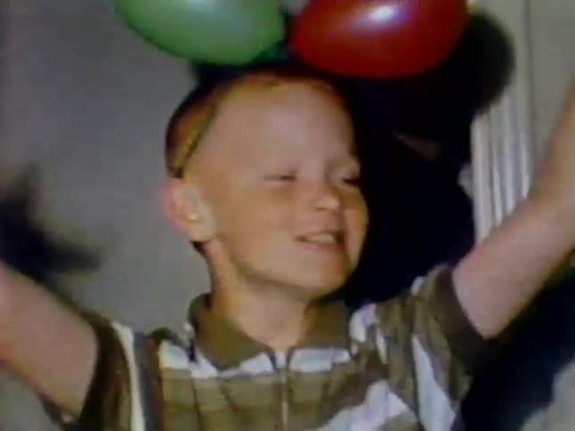 A boy walks like a monster with balloons on his head