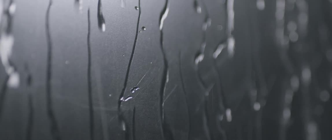 Water drizzling down a piece of glass