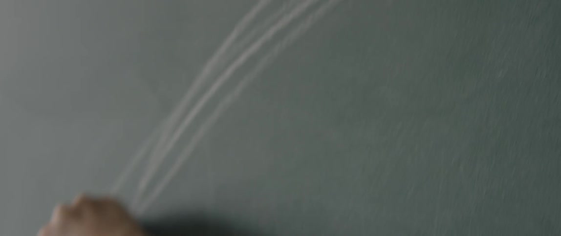 A child is drawing with chalk on a chalkboard