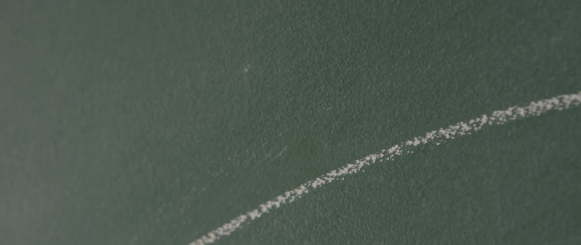 A person draws a line with chalk