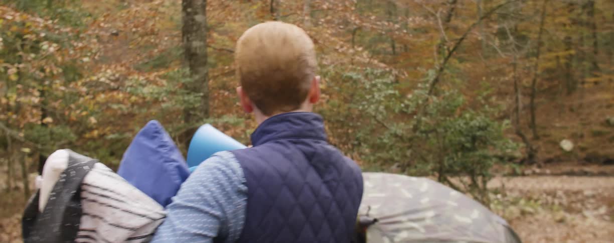 A man carries over some supplies to a tent