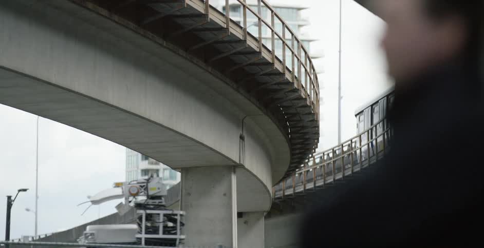 Blurry image of a man standing in front of a bridge