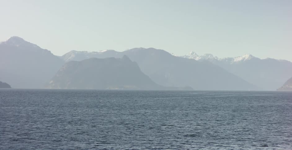 A mountain range lies across from a body of water