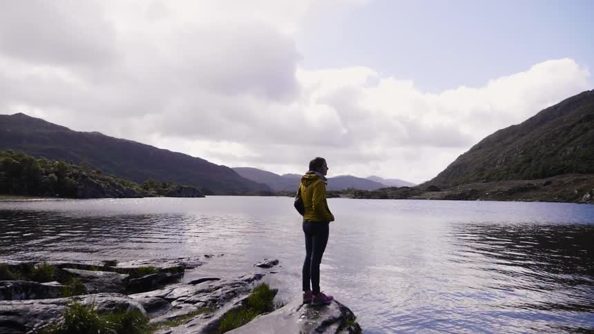 Person standing at edge of a lake looking out