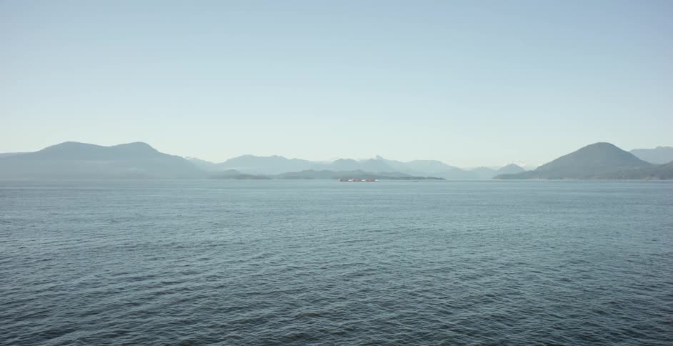 An aerial shot of water and misty hills