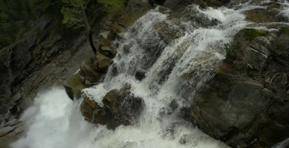 The water rages falling off the side of the waterfall
