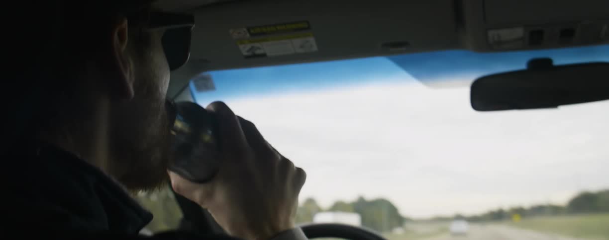 Smiling woman unscrews a jug and a man driving takes a drink
