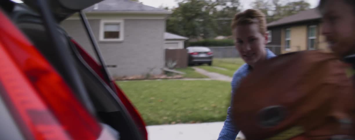 Man and woman pack camping equipment into a vehicle