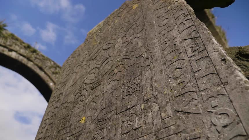 Carvings cover the wall of stone ruins