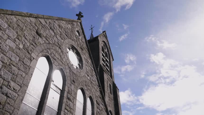 Crosses atop a building on a partly cloudy day