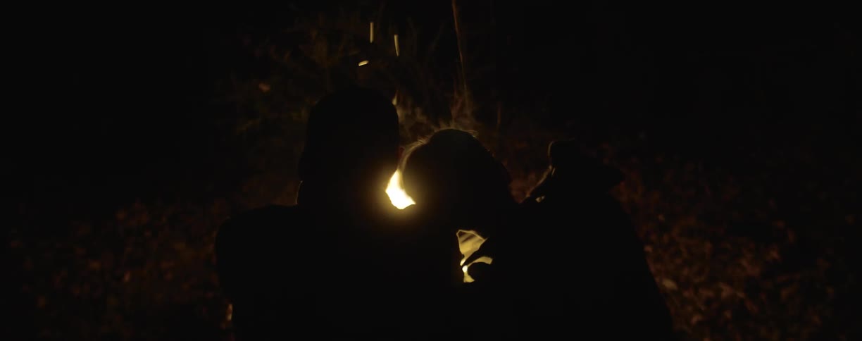 Two people sitting in front of a fire