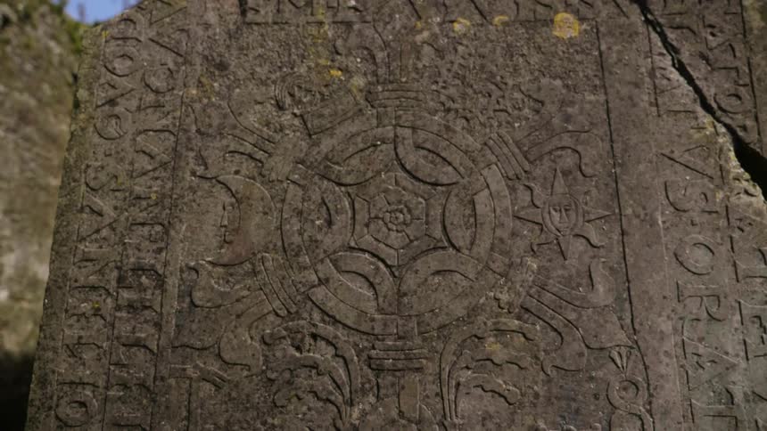 A zooming in view of  a large stone with designs on it