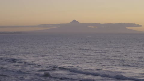 Waves gently crash on the beach at dusk