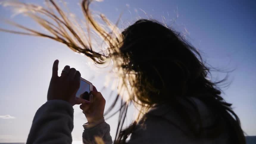 A woman photographing the water