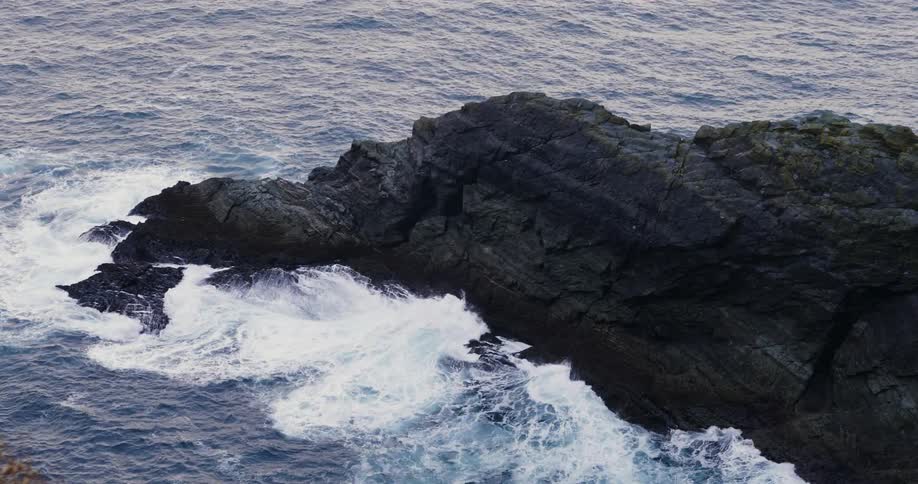 Rocks go out into the water with high waves