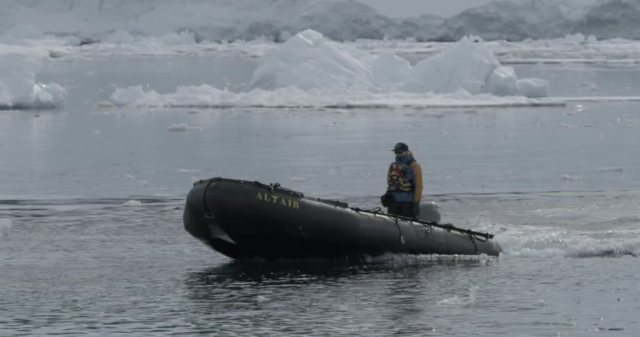 A person driving a small boat in icy water