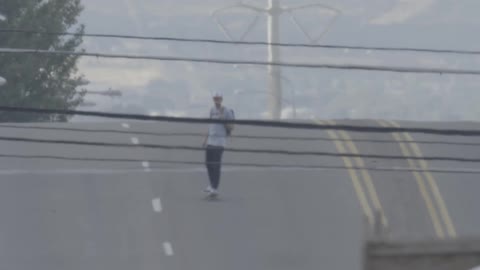 Man skateboarding quickly down a sloping road