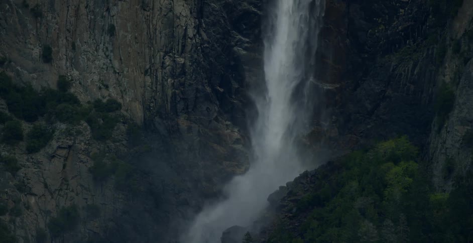 A waterfall gushes over a rocky cliffside