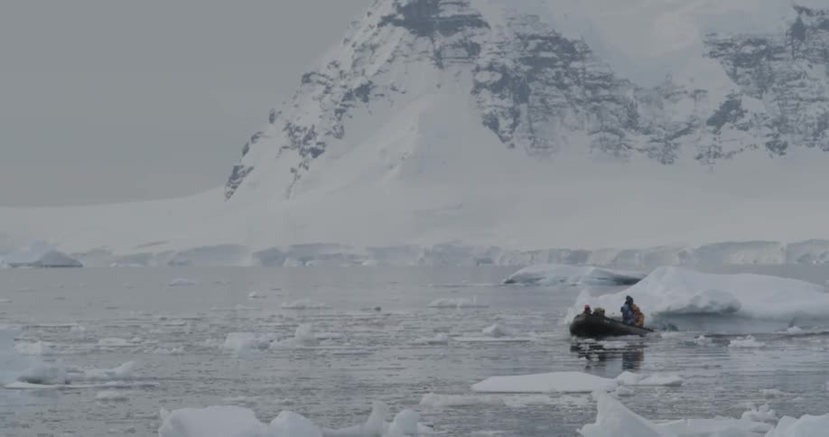 A zodiac travels through icy water