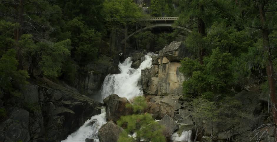A waterfall gushes over a rocky mountainside