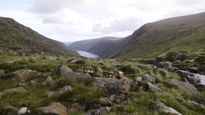 Rocky landscape next to hills and a stream