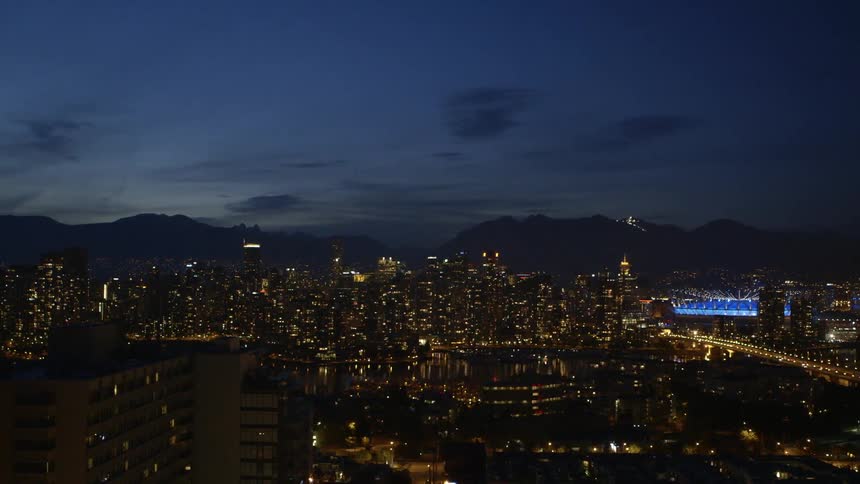 A large city sitting on a bay shown at night