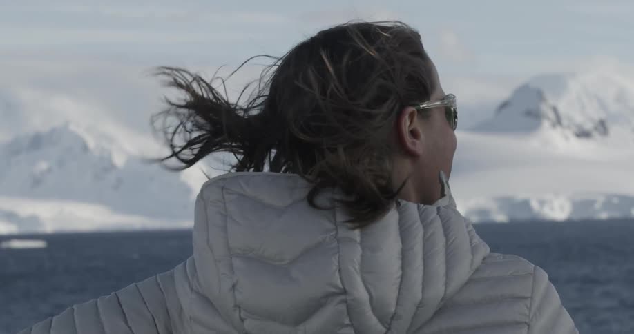 A woman's hair blows in the breeze with snowy background