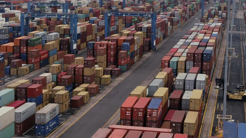 The docks have vehicles moving containers onto ships