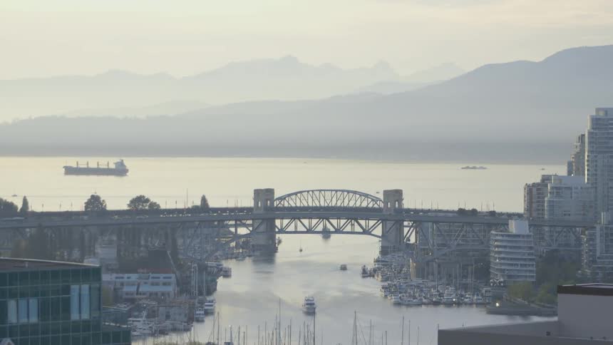 View of an old bridge and a waterway near a city on a hazy day