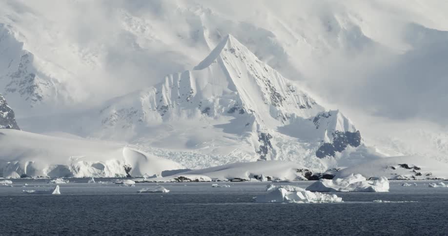 Epic snow covered Mountain behind icy ocean scene