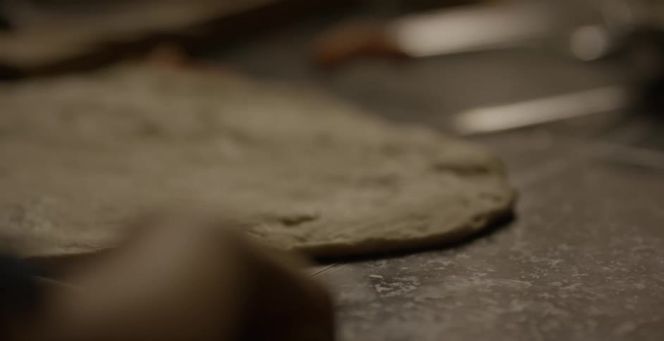 A person rolls dough with a baking pin